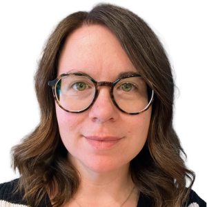 Headshot of Dr. Ami Goulden. She is a white woman with wavy brunette hair, tortoiseshell glasses, and is wearing a black sweater.