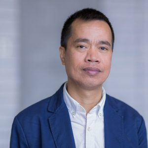 Headshot of Dr. Gerald Tembrevilla. He is an asian man with short dark hair and is wearing a blue blazer.