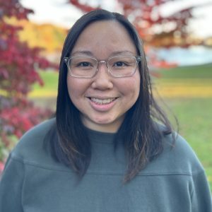 Headshot of instructor Nina Bernard-Tran. She is an asian woman with shoulder length dark hair, clear rectangular glasses, and is wearing a grey sweater.